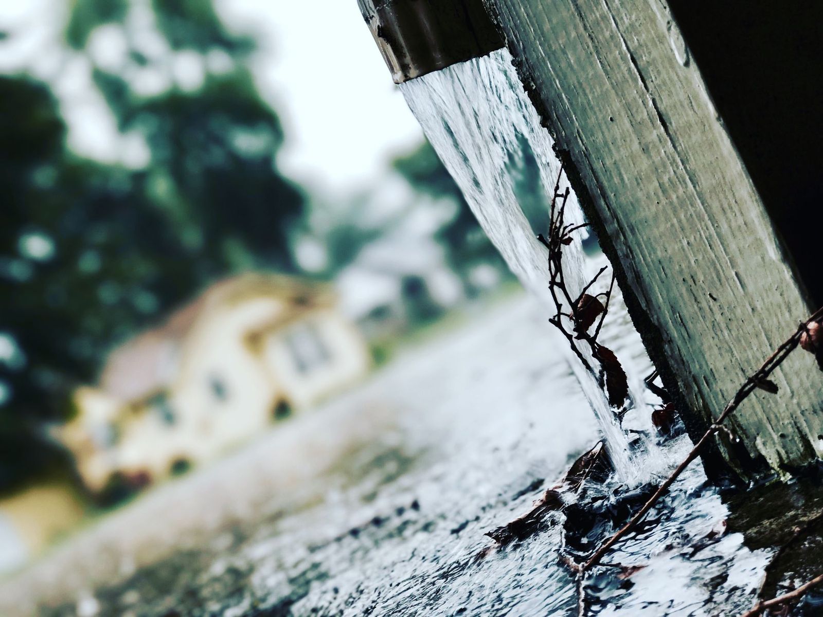 Regenwasser läuft bei Unwetter aus einer Dachrinne